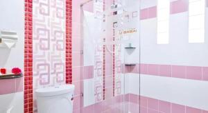 a bathroom with pink and white tiles and a toilet at U-Sabai Park Resort in Ban Kao +90 photos