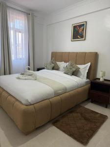 a large bed in a bedroom with a large couch at Jay Homes -Ultra Modern Naivegas Apartments in Naivasha