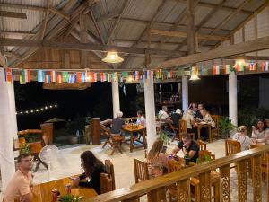 a group of people sitting at tables in a restaurant at Kohjum Relax Beach in Ko Jum