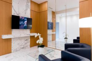 een lobby met een open haard en een tv aan de muur bij Foresteria La Vista in Cremona