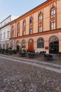 een gebouw met tafels en stoelen ervoor bij Foresteria La Vista in Cremona