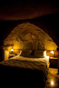 a bedroom with a bed with a carving on it at Ages in Cappadocia Premium in Uchisar