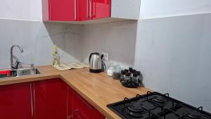a kitchen with red cabinets and a stove top oven at Le cocon drargua in Agadir