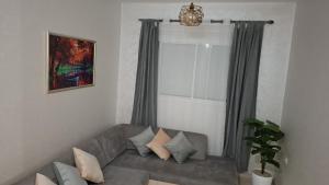 a living room with a gray couch and a window at Le cocon drargua in Agadir +1 photo