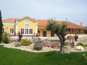 una casa amarilla con un jardín delante de ella en Casa Agricola Quinta Da Junqueira, en Reguengo Grande