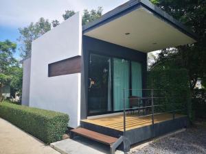 a small house with a glass door and a deck at The Lofts Eco Resort in Ban Kut Khamin