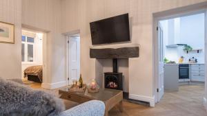 a living room with a fireplace and a tv at Plas Madoc Lodge in Conwy