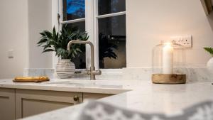 a kitchen with a sink and a candle on a counter at Plas Madoc Lodge in Conwy +42 photos