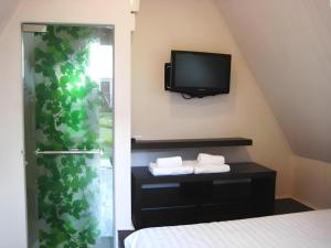 a bedroom with a bed and a tv on the wall at The Park Nangrong Resort in Nang Rong