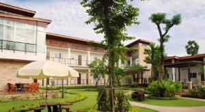 a building with an umbrella and a courtyard at The Park Nangrong Resort in Nang Rong