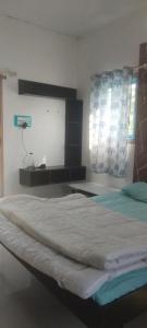 a large bed in a room with a desk at ViRa Farm in Sūlagiri