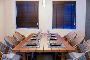 a long wooden table with chairs in a room with windows at Villa MILA ONNA in Onna