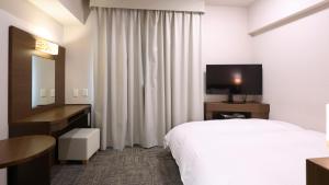 a hotel room with a bed and a sink and a mirror at Dormy Inn Premium Shibuya-jingumae in Tokyo