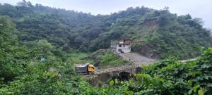 a train is crossing a bridge on a mountain at Hotel The Ultimate in Solan