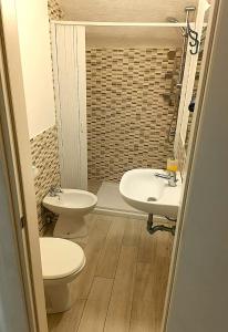 a bathroom with two toilets and a sink at Ostello dei Sassi - Matera Hostels in Matera
