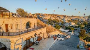 an aerial view of a building with hot air balloons in the sky at Cappadocia Inn Cave Hotel in Göreme