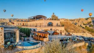 a large building with a hot air balloons in the sky at Cappadocia Inn Cave Hotel in Göreme
