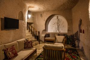 Ages in Cappadocia Premium في أوشيسار: غرفة معيشة مع أريكة وتلفزيون ودرج