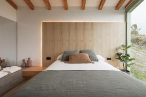 a bedroom with a large bed with a large window at Cabañas Ribeira Sacra in Parada del Sil