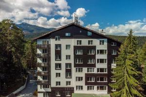 un grande condominio con una montagna sullo sfondo di Sunlit Forest Suite a Borovets