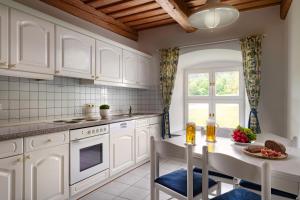 a kitchen with white cabinets and a table at Klosterhof St. Salvator in Bad Griesbach +41 photos