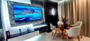 a living room with a table and a tv on a wall at Studio de charme face corniche de Casablanca in Casablanca