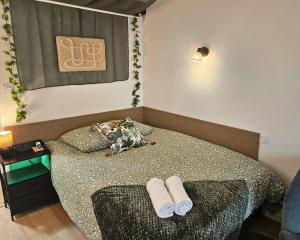 Un dormitorio pequeño con una cama con toallas. en Fontaine - Centre - Wifi - Clim, en Dax