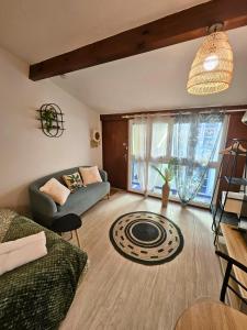 una sala de estar con un sofá y una mesa en Fontaine - Centre - Wifi - Clim, en Dax