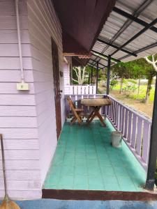 a porch of a house with a picnic table at เขาค้อ ภูดาว Resort & Camping in Khao Kho