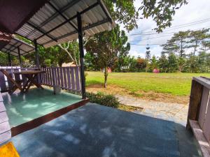 a porch with a picnic table and a field at เขาค้อ ภูดาว Resort & Camping in Khao Kho +52 photos