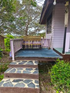 a bench on a patio in front of a house at เขาค้อ ภูดาว Resort & Camping in Khao Kho