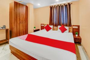 Un dormitorio con una cama grande con almohadas rojas. en Hotel O Karaikal Beachview Formerly KK Residency, en Karaikal