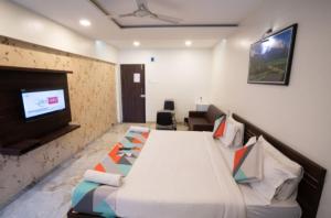 a hotel room with a bed and a tv at Classic Residency in Pune