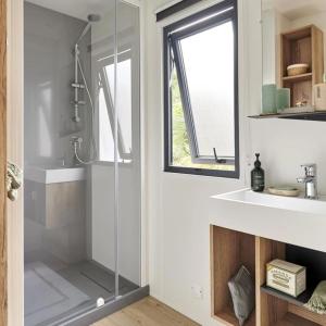 Belmont-sur-RanceにあるCamping Sud AVEYRON dans le Rougierのガラスのシャワーと洗面台を備えたバスルーム