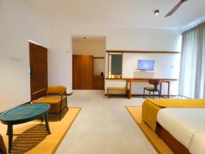a hotel room with a bed and a desk and a table at Te Dalu Resort & Spa in Ella