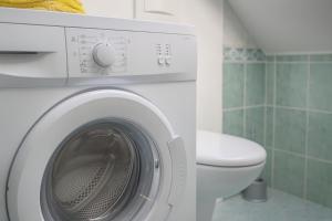 een witte wasmachine in een badkamer met een toilet bij Sunset Apartments Bohinj in Bohinj