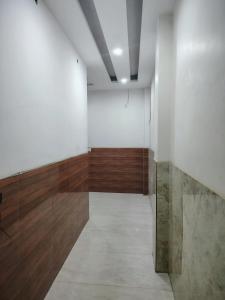 Habitación con pared blanca y suelo de madera. en Roop Mahal, en Jāmb