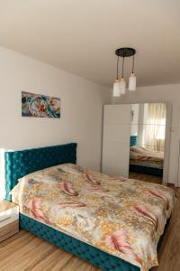 Un dormitorio con una cama con cabecero azul. en Apartmani Loznica Premia, en Loznica