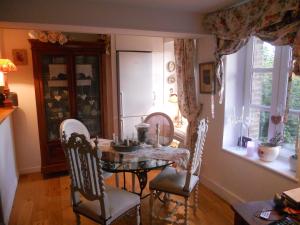 a dining room with a table and chairs and a window at chambres d'hotes le nid du phare avec option jacuzzi privé in Honfleur
