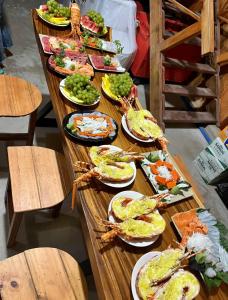 a long wooden table filled with plates of food at Mộc Homestay Đảo Phú Quý in Cu Lao Thu +54 photos