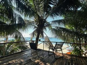a deck with two chairs and a palm tree at Mộc Homestay Đảo Phú Quý in Cu Lao Thu