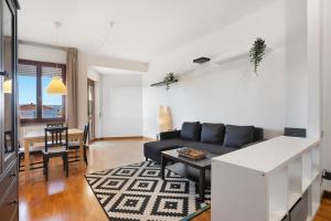 two-room apartment sea view في مارينا دي كارّارا: غرفة معيشة مع أريكة سوداء وطاولة