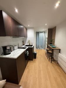 a kitchen with wooden floors and cabinets and a counter top at Studio Bagneux Bourg la Reine in Bagneux