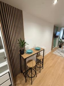 a dining room table with two blue plates on it at Studio Bagneux Bourg la Reine in Bagneux