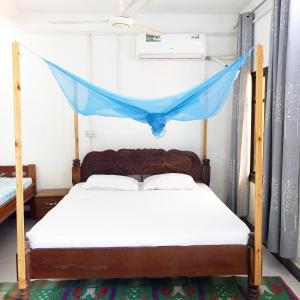 Mamdalis Private Rooms Stonetown في Ngambo: غرفة نوم بسرير مع ناموسية