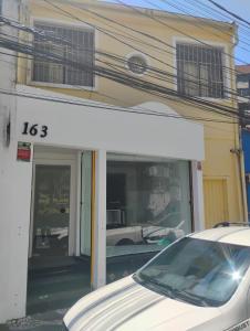 Un coche blanco aparcado delante de una tienda en Hostel Barra 163, en Salvador