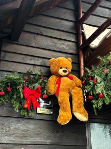 Een teddybeer zit op een kerstkrans. bij Cabana LoSt Ventoc in Vulcan