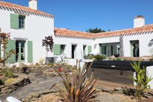 ein weißes Haus mit einem Garten davor in der Unterkunft Magnifique villa Piscine Spa Billard in L'Ile d'Yeu