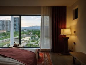 Postel nebo postele na pokoji v ubytování Turpan Rizamat Manor