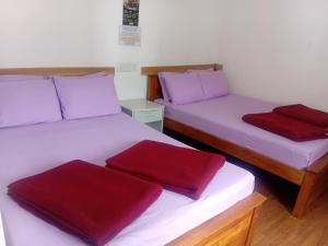 T Bungalow في نوارا إليا: سريرين في غرفة وسائد حمراء عليهم